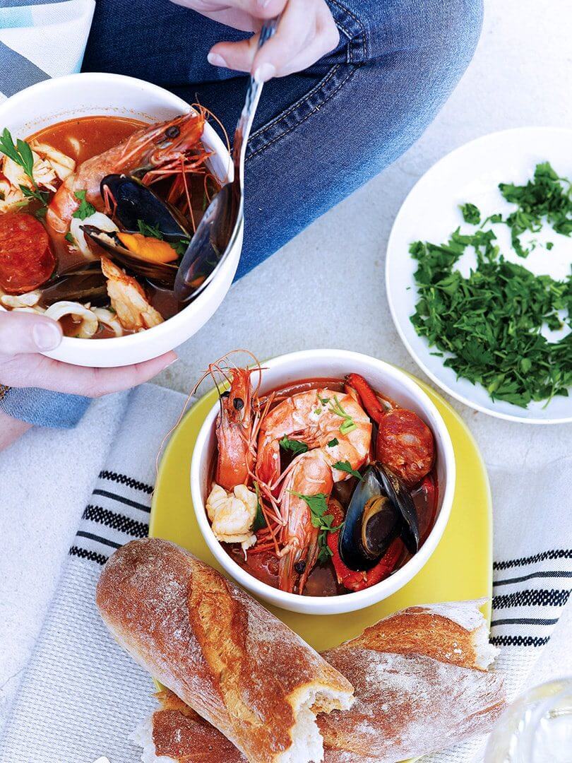 Two bowls of rich seafood bisque with a loaf of French bread. Photograph by Elsa Young. Two bowls of rich seafood bisque with a loaf of French bread. Photograph by Elsa Young.