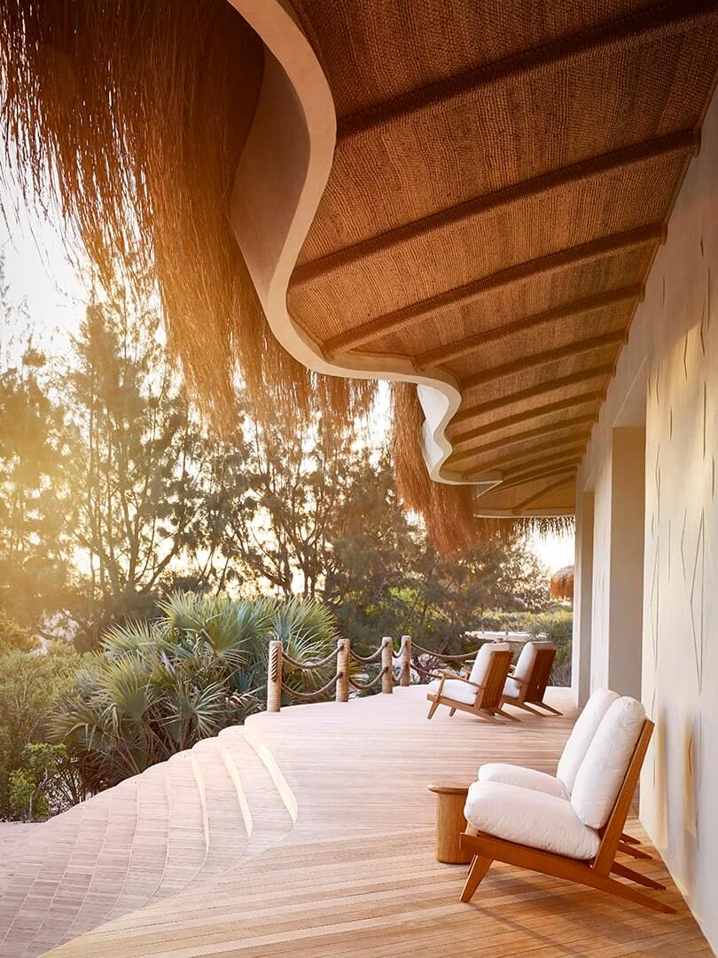 Chairs on a wooden deck under a magnificent hand-crafted grass roof overhang at Kisawa Sanctuary. Mozambique. Photo by Elsa Young. Chairs on a wooden deck under a magnificent hand-crafted grass roof overhang at Kisawa Sanctuary. Mozambique. Photo by Elsa Young.