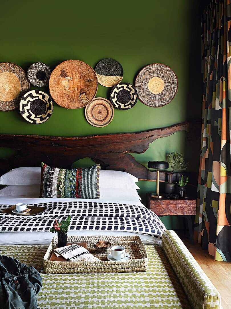 Eclectic bedroom with African bed throws and woven baskets on the walls at Toulon House in South Africa. Photo by Elsa Young. Eclectic bedroom with African bed throws and woven baskets on the walls at Toulon House in South Africa. Photo by Elsa Young.