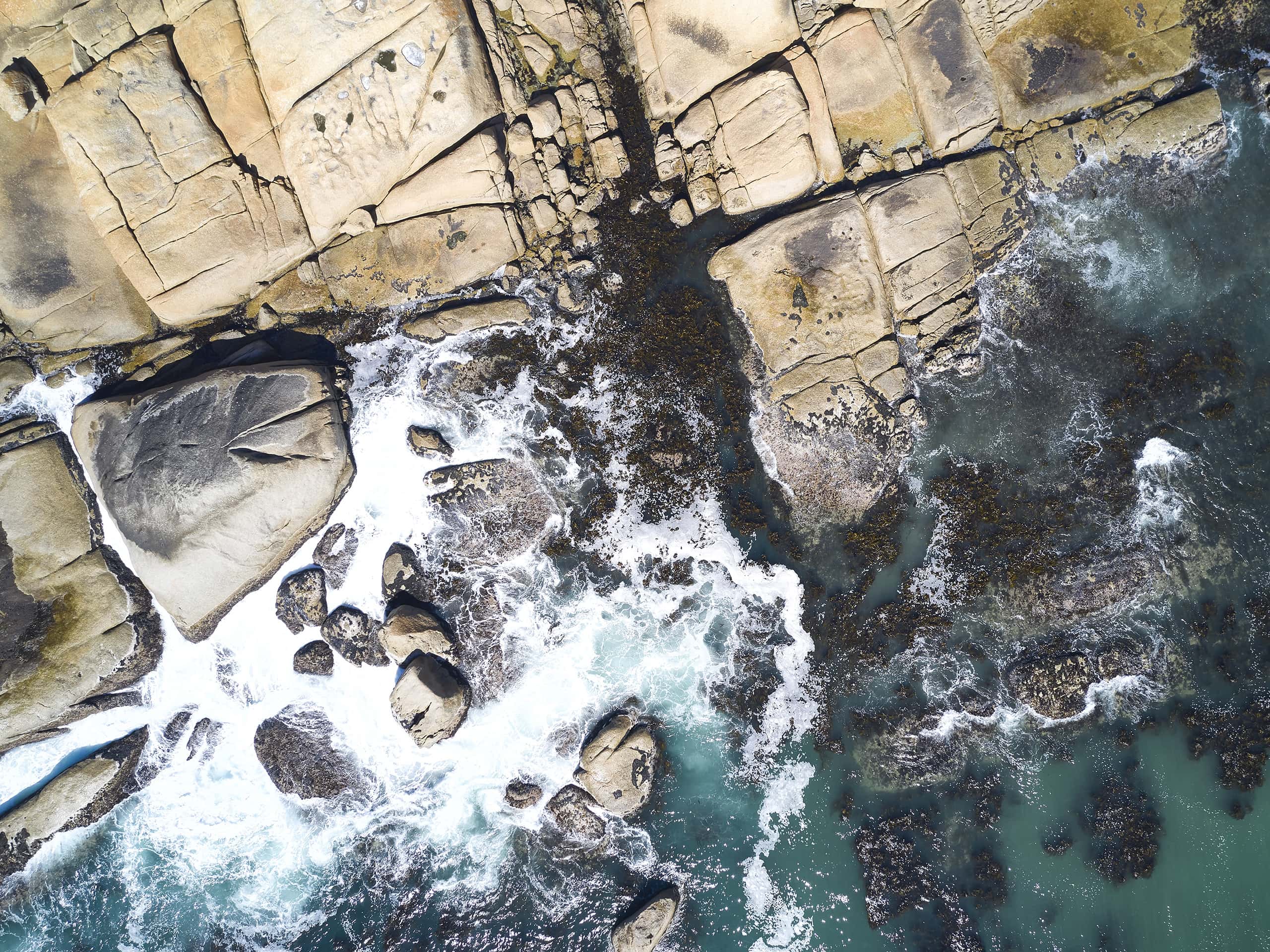 Evocative drone photograph of waves crashing into rocks in the Western Cape, South Africa. Photograph by Elsa Young. Evocative drone photograph of waves crashing into rocks in the Western Cape, South Africa. Photograph by Elsa Young.