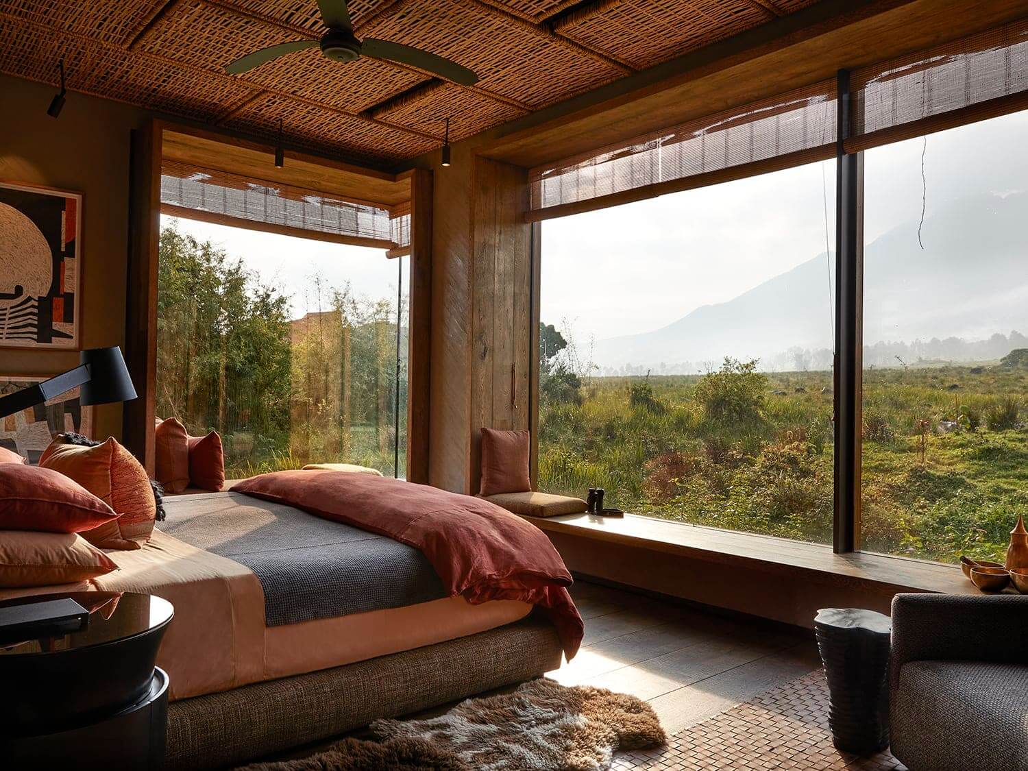 Beautiful bedroom with woven ceilings and huge plate glass windows overlooking a distant volcano at Singita Kwitonda, Rwanda. Photo by Elsa Young Photography. Beautiful bedroom with woven ceilings and huge plate glass windows overlooking a distant volcano at Singita Kwitonda, Rwanda. Photo by Elsa Young Photography.